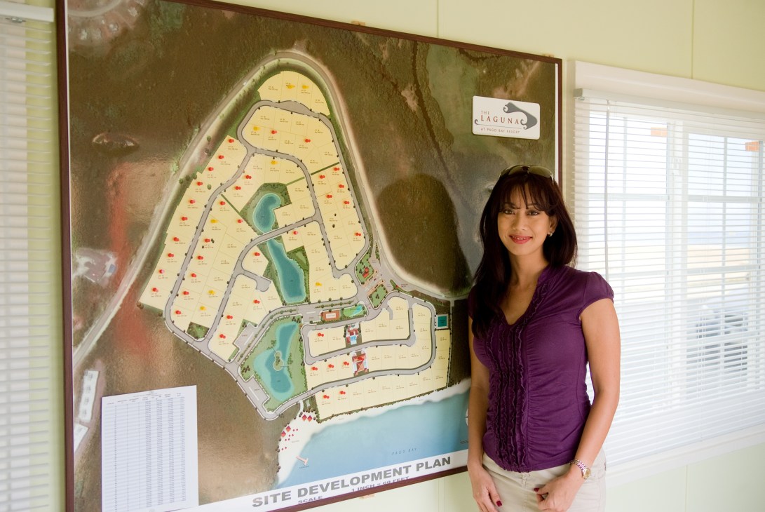 Wendy Hortiz, principal broker for The Laguna, stands beside a site development plan map of the Pago Bay project.