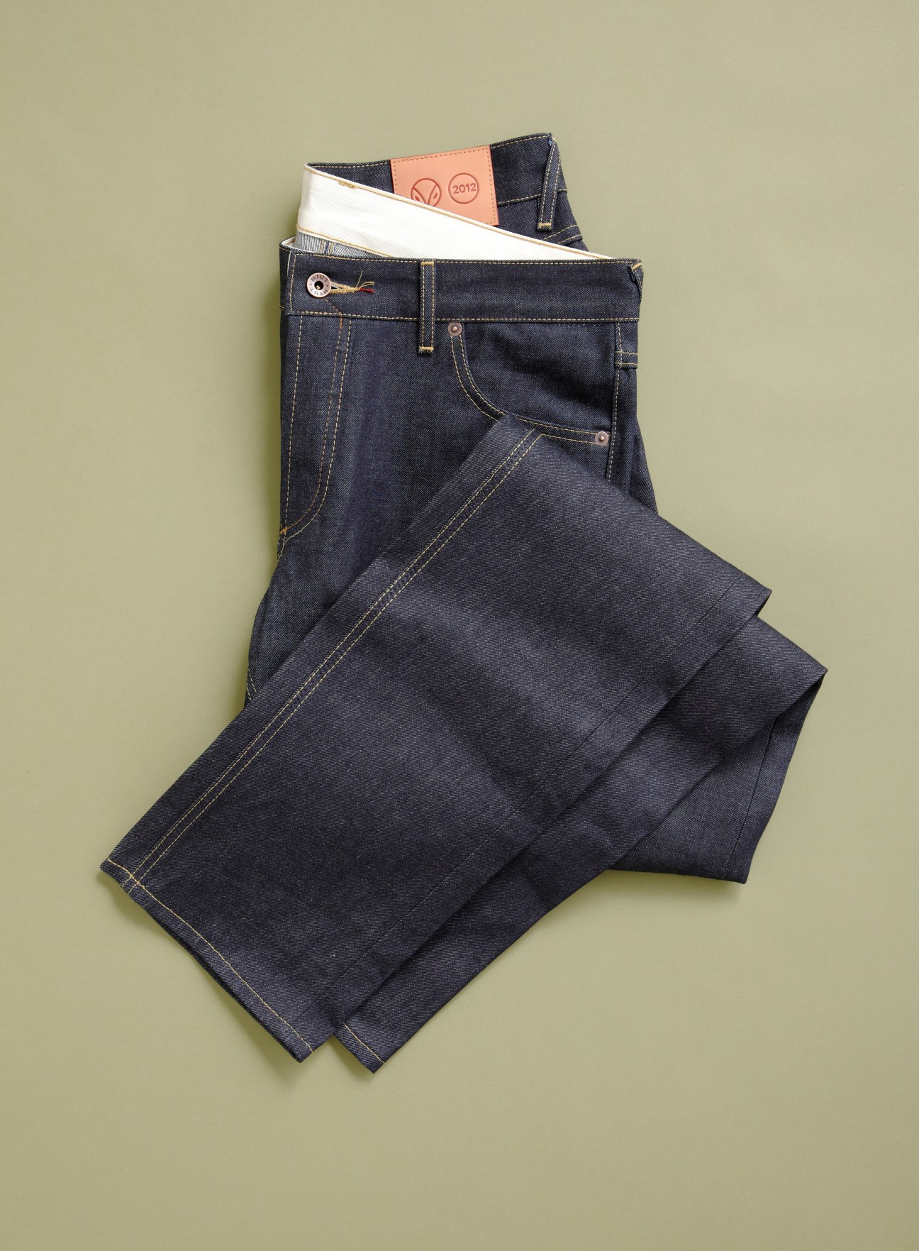 Hiut denim jeans folded with packaging on a beige background.