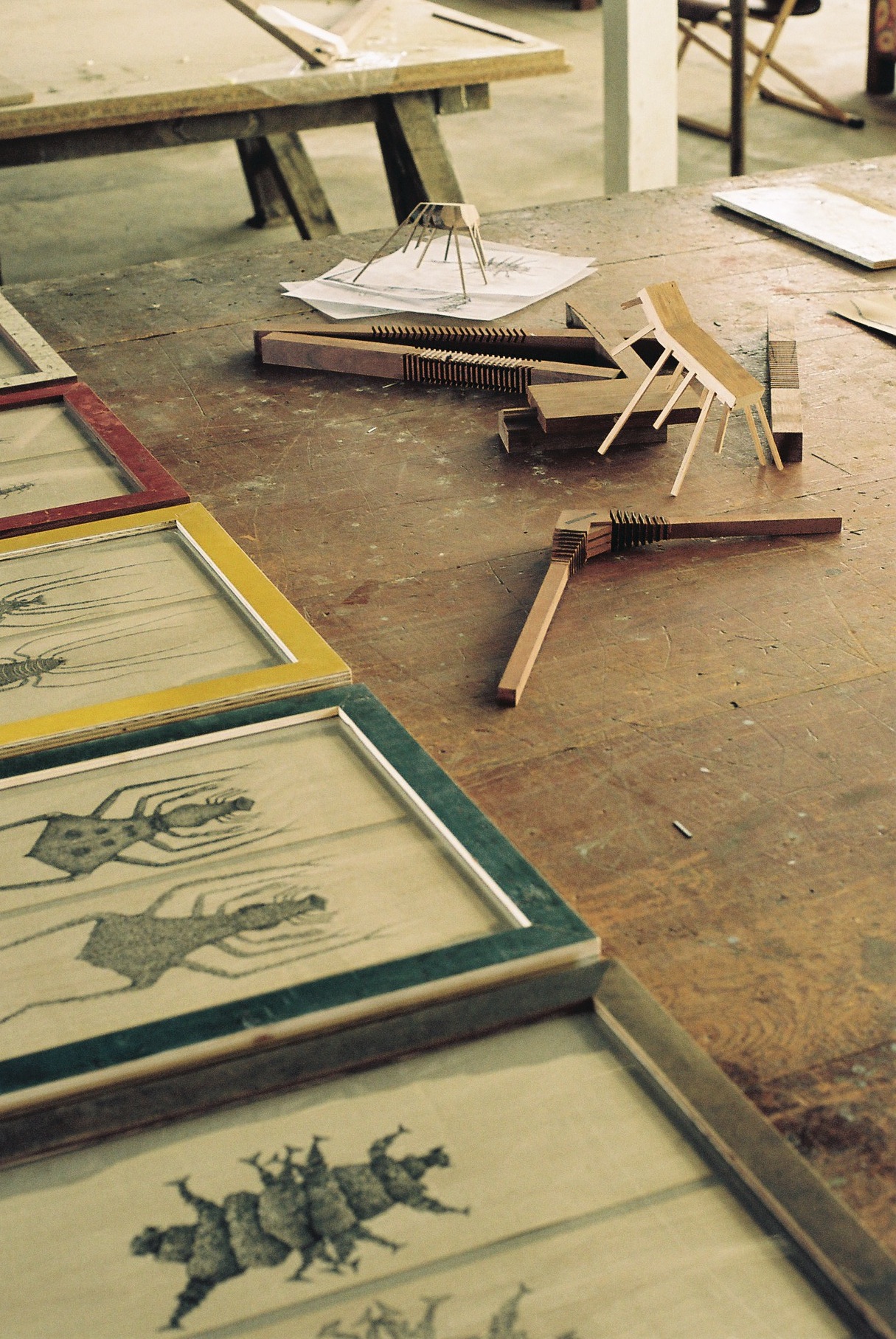 Woodworking tools and sketches scattered on a workshop table at The Pattern Shop.