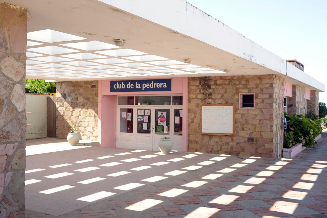La Pedrera social club exterior with pink entrance and brick building under pergola.