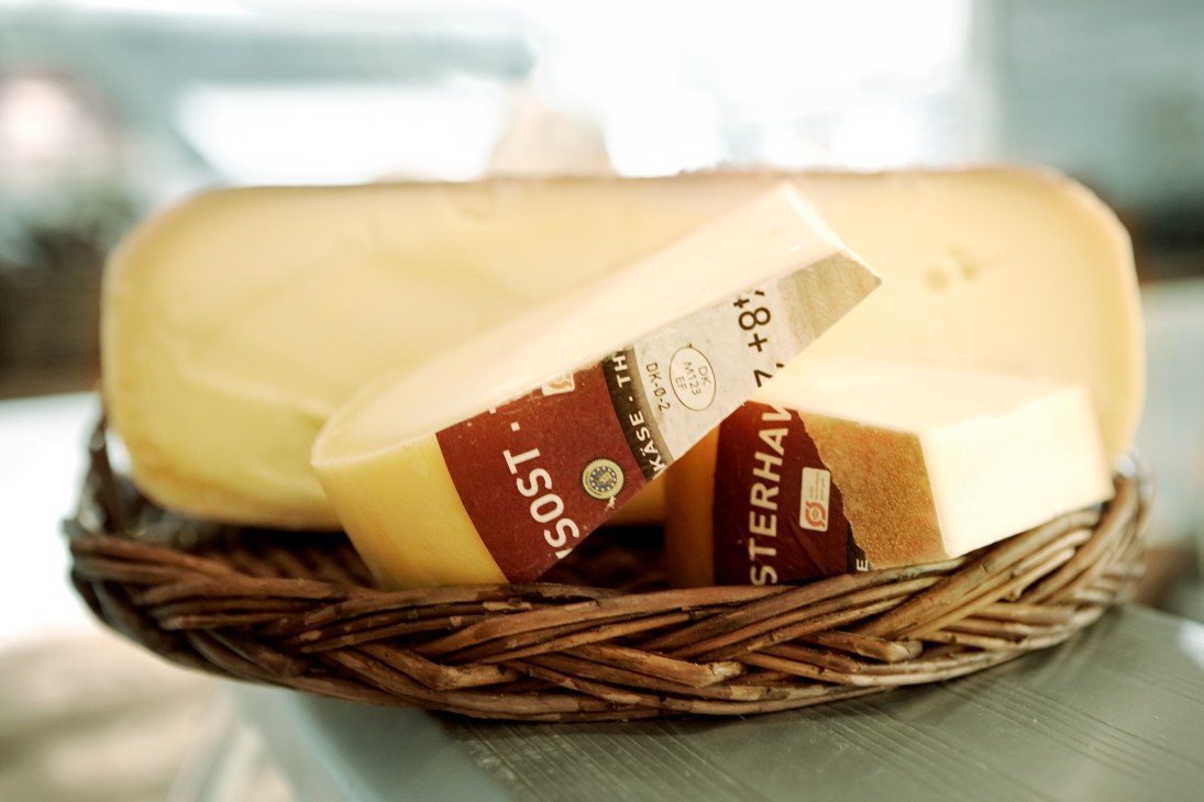 Vesterhavsost North Sea cheese with red label displayed in a woven basket.