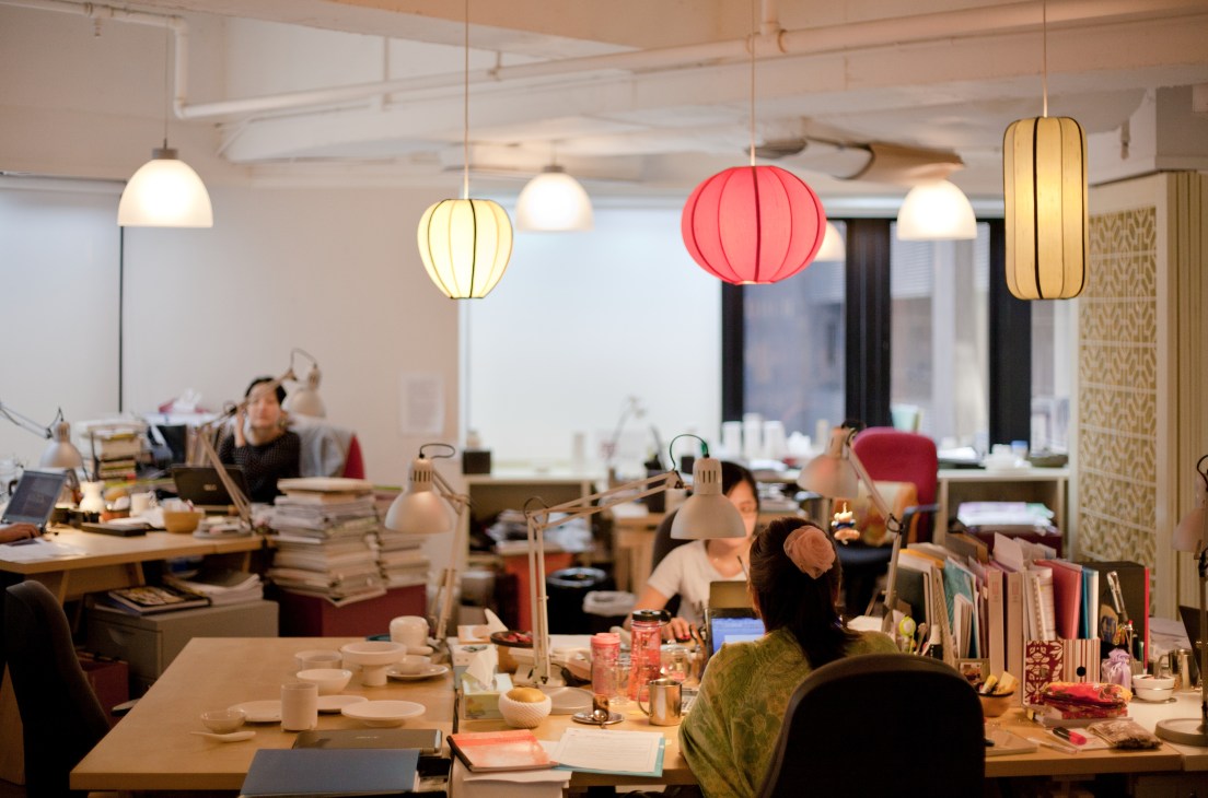 Office workspace at Jia Inc in Kowloon with hanging pendant lights in various colors and shapes.