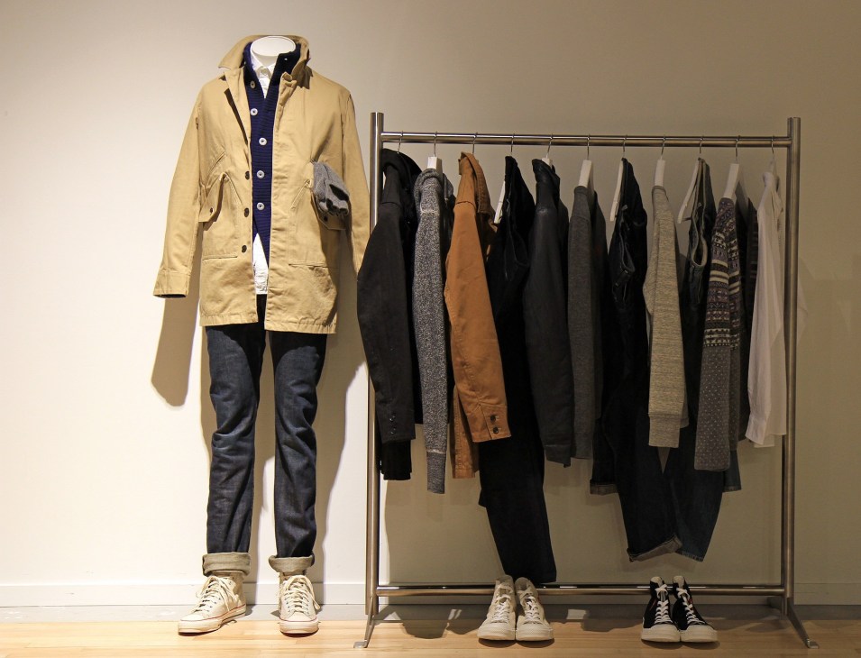 Menswear display at Roden Gray showing a mannequin in yellow jacket and dark jeans with clothing rack and sneakers.