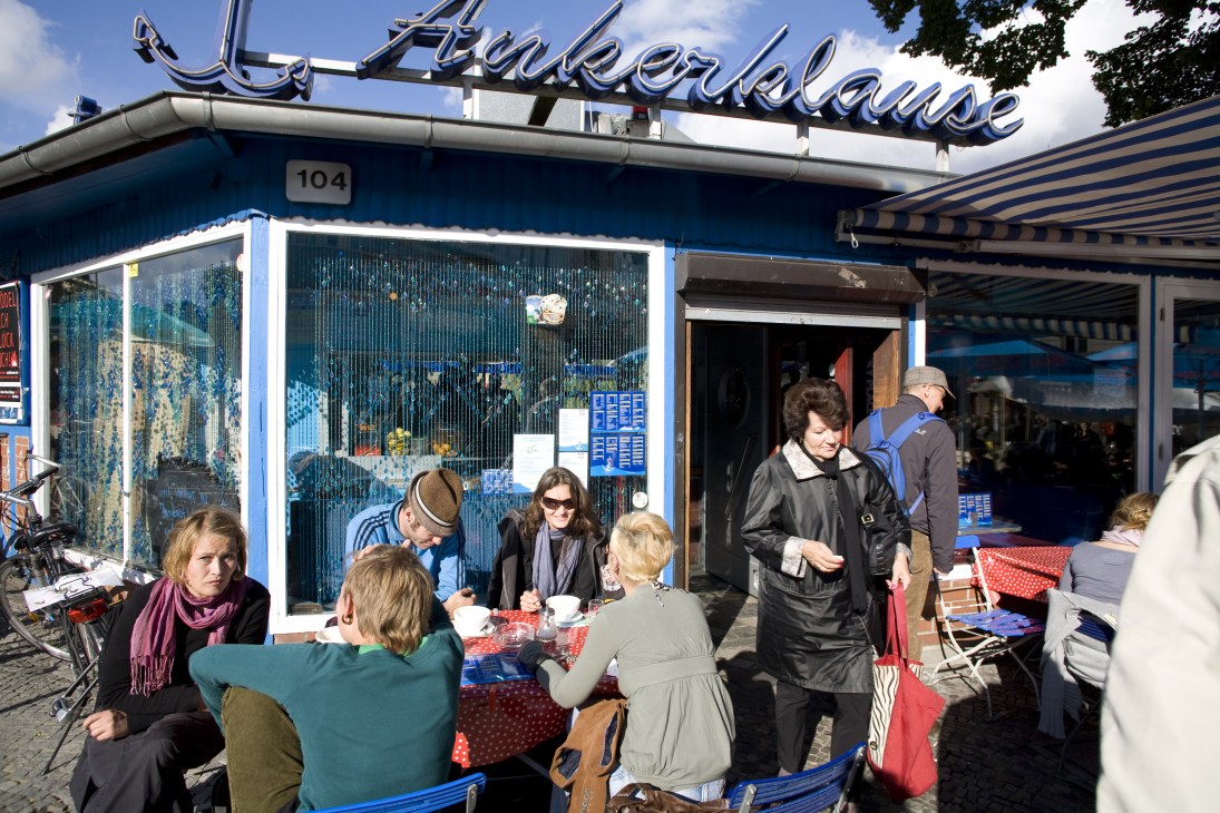 Patrons seated at outdoor tables outside Ankerklause bar on the Landwehr canal in Neukölln, Berlin.