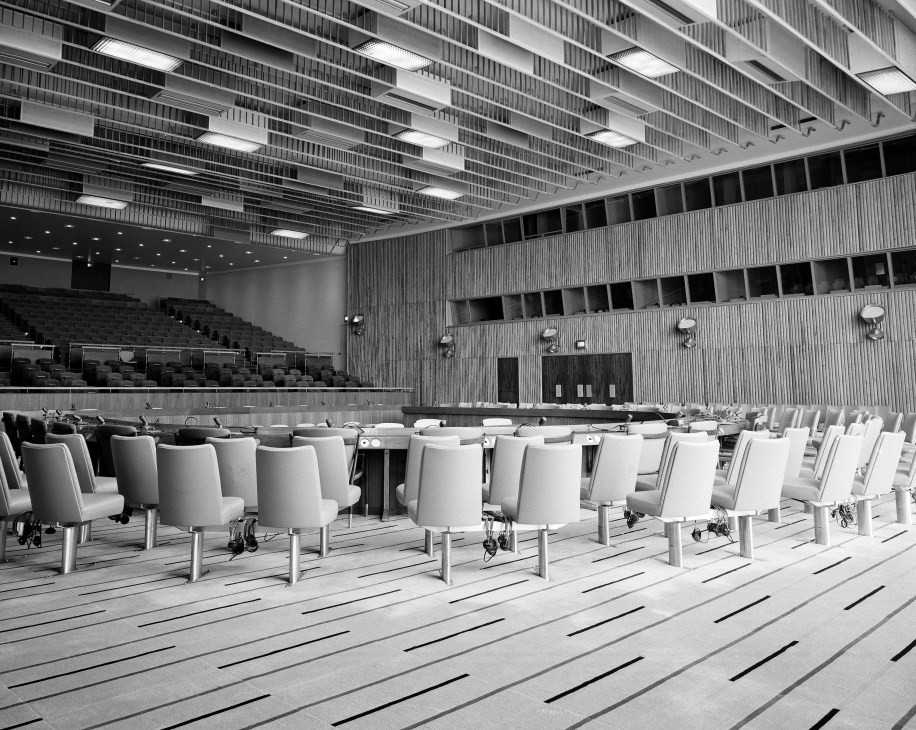 Black and white archive photo of the Trusteeship Council Chamber showing mid-century modern furniture arranged in a horseshoe configuration facing each other.
