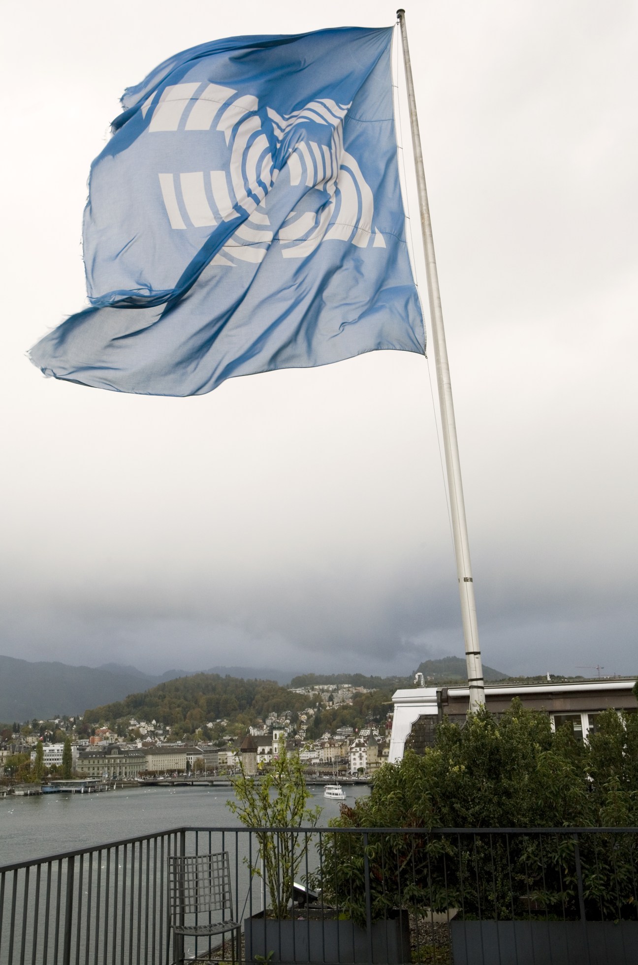 EF company flag flying over Lucerne with lake and mountains in background.
