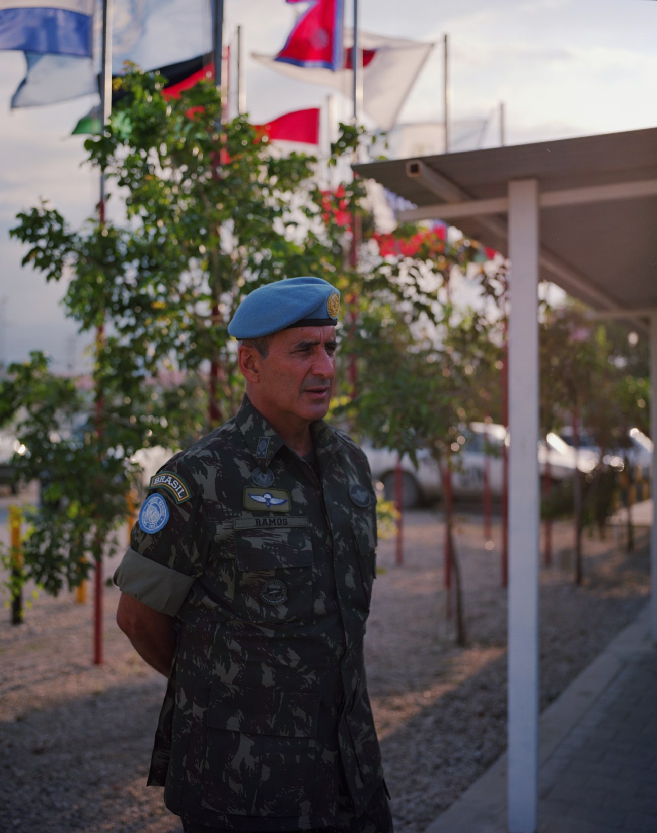 Brazilian Force Commander Major General Luiz Eduardo Ramos Pereira in blue beret and camouflage uniform at Delta Camp with flags in background.