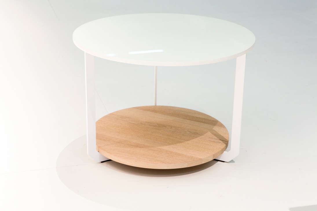 Modern round table with white cylindrical base and light wood circular top.