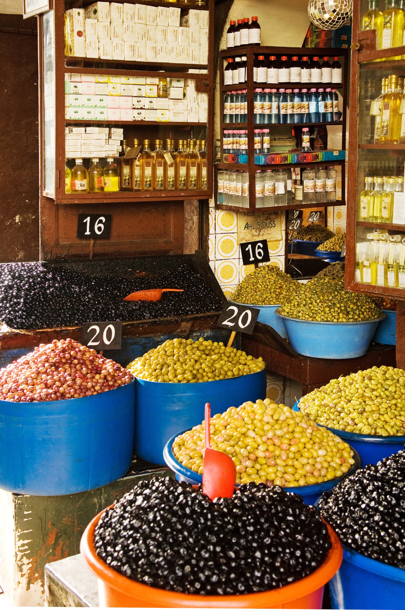 Colorful olive varieties displayed in blue and orange bowls at Habbous market stall in Casablanca.