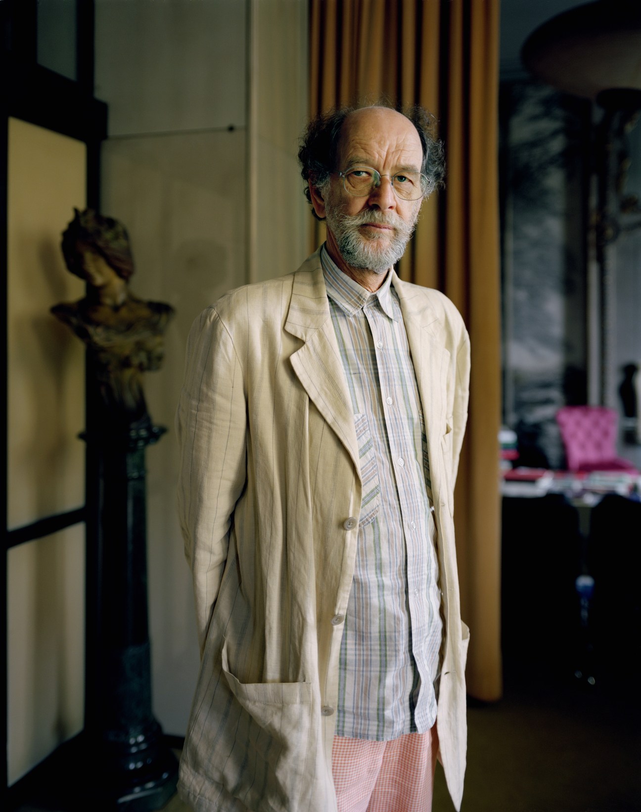 Fulvio Ferrari, curator at Casa Mollino, standing in an elegant interior wearing a light blazer and striped shirt.