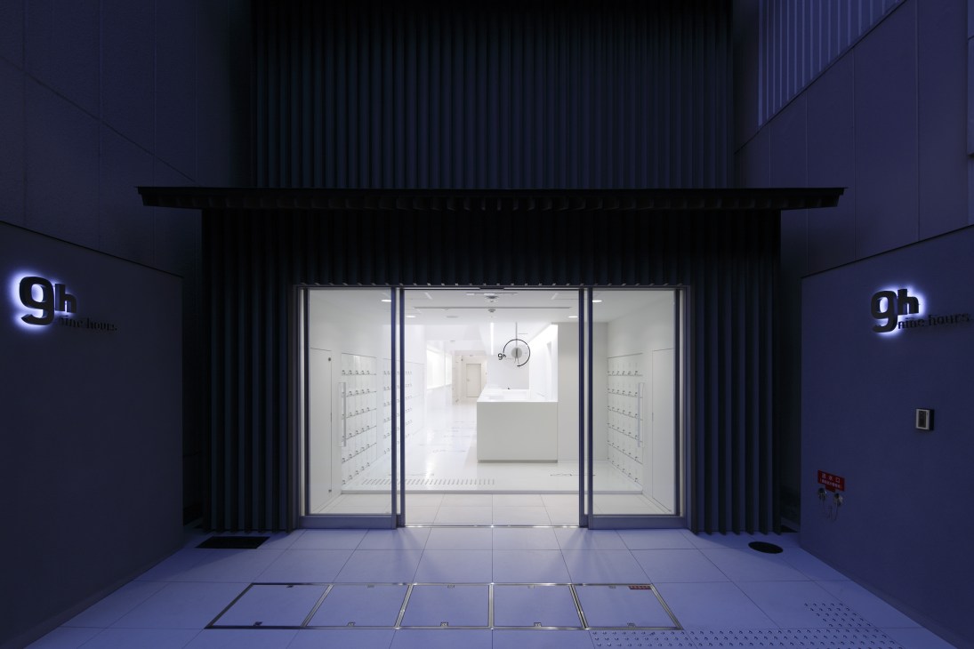 9 hours hotel entrance in Kyoto with illuminated signage and modern minimalist interior design.