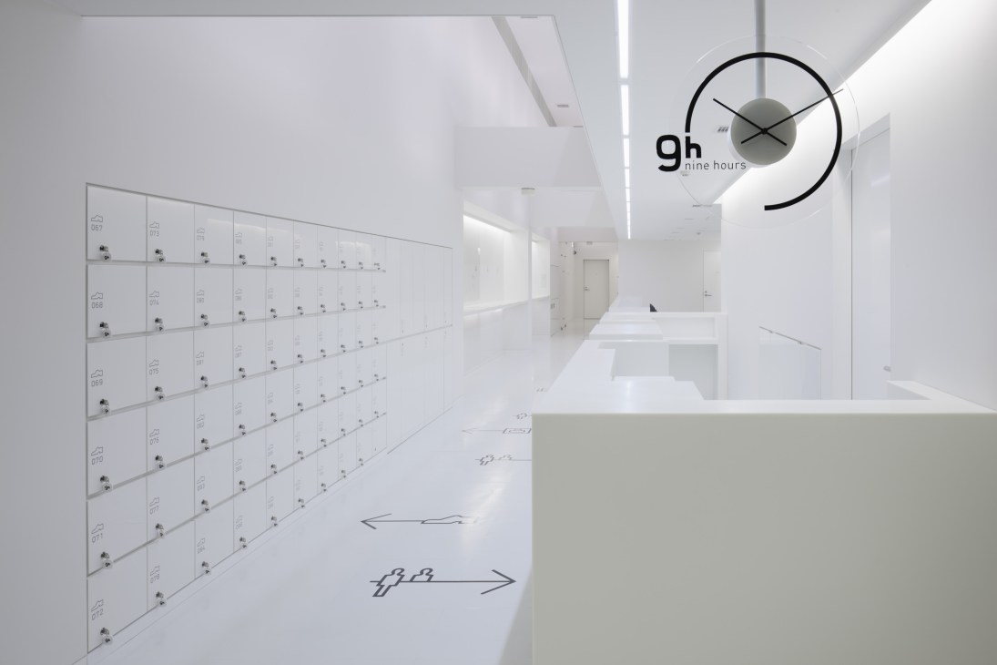 9 hours Kyoto hotel reception area with white lockers and minimalist signage