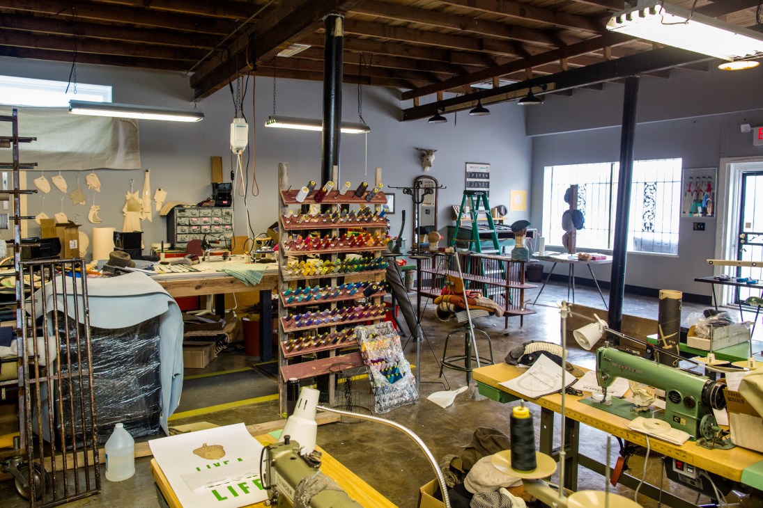Spacious workshop interior with bow tie displays, work tables, and manufacturing equipment.
