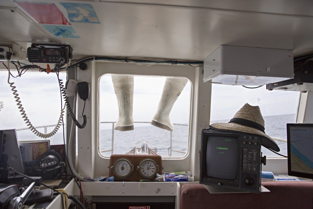 The Harvey family crew taking a rest break on the boat, visible through the wheelhouse window.