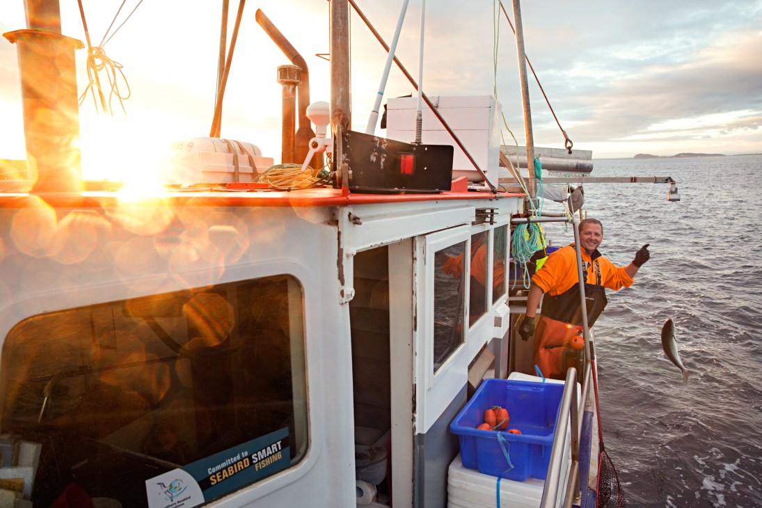 Daniel Harvey pulling in the longline with fish on hooks from the Royal Salute fishing boat.