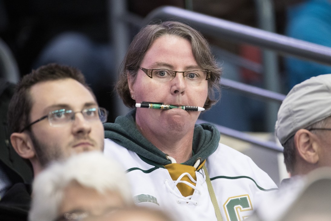 Hockey fan in London Knights jersey holding a Knights-branded pen, ready to take notes during the game