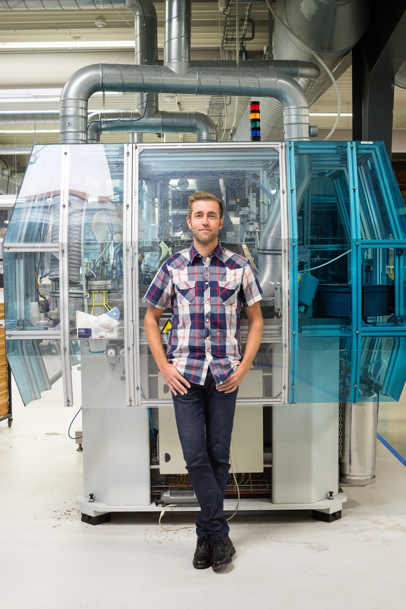 Michael Rohde Böwadt, VP of product management, stands in front of industrial speaker testing equipment in a factory.