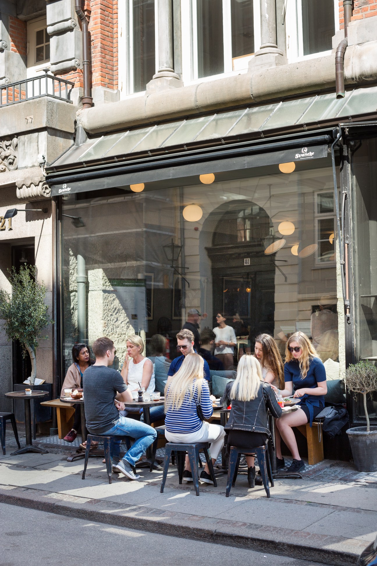 Customers seated at outdoor tables outside The Union Kitchen café with large storefront windows and brick building facade.