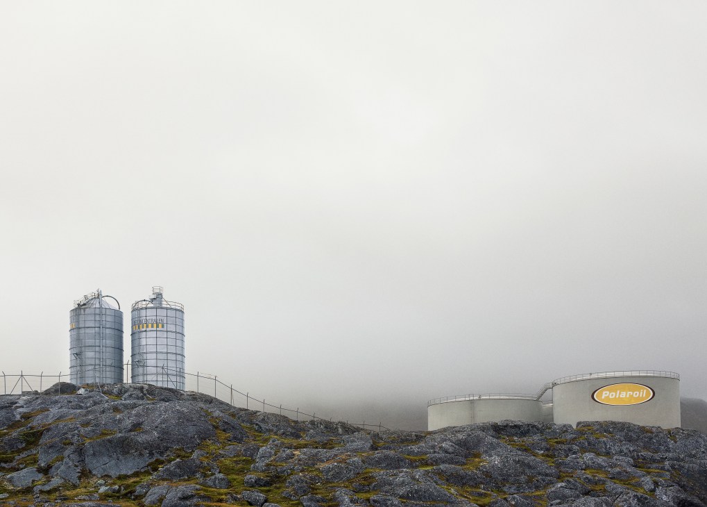 Polaroil industrial storage tanks and silos on rocky terrain in Greenland.