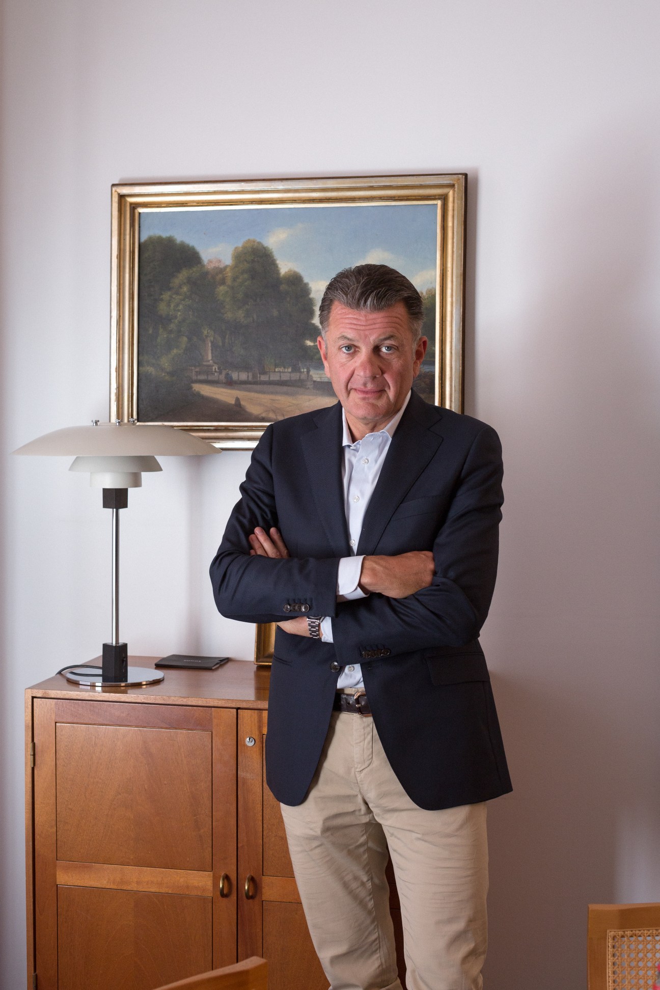 Lars Thylander, property firm owner, poses in his office with arms crossed wearing a dark blazer.