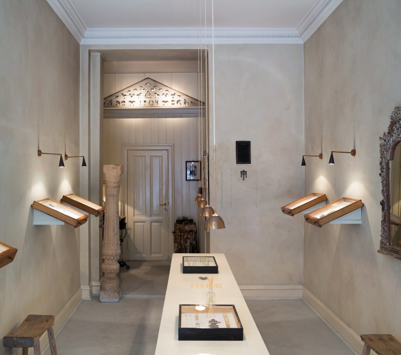 Interior of Louise Grønlykke's jewellery shop displaying items in lit cases within a classical white gallery space.