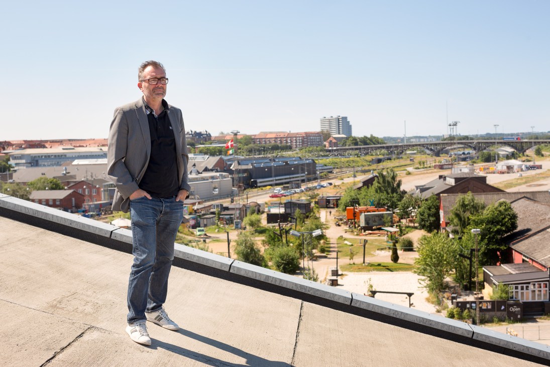 City architect Stephen Willacy stands on a rooftop overlooking Aarhus's harbourfront development and industrial areas.
