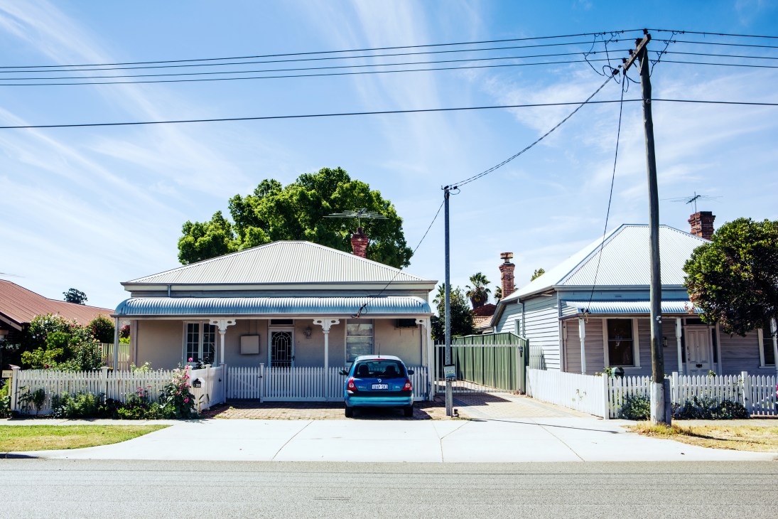 Row of timber-and-iron workers' cottages with blue corrugated iron roofs and white picket fences in Maylands, Perth.