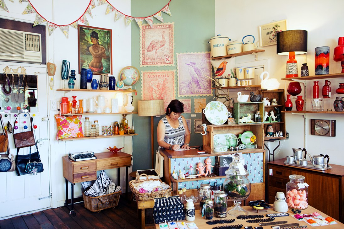 Interior of Vintage Emporium shop filled with vintage homeware, collectibles, and mid-century furniture displayed on shelves and surfaces.