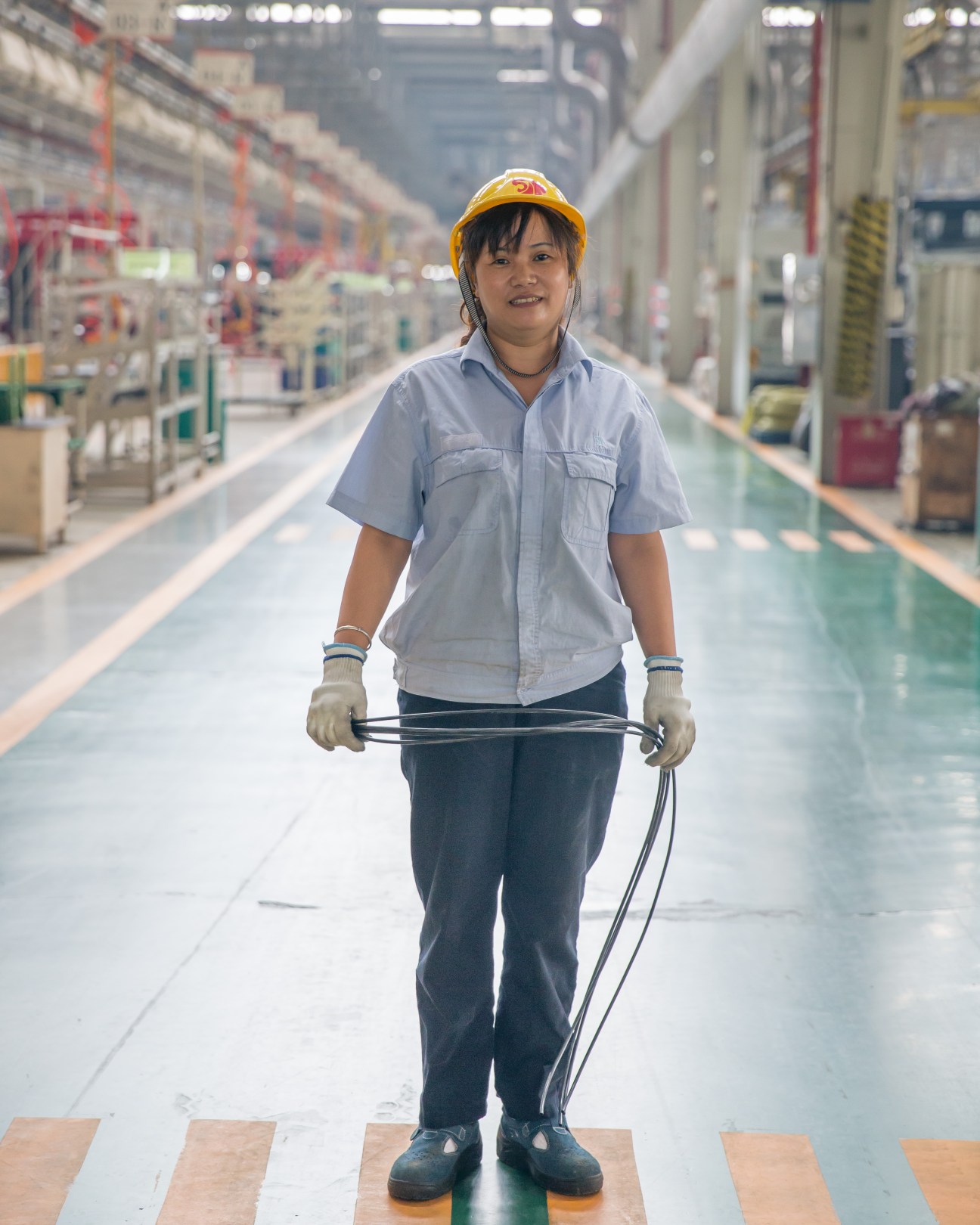 Worker at the Saic-Iveco factory wearing a hard hat and safety gear on the factory floor