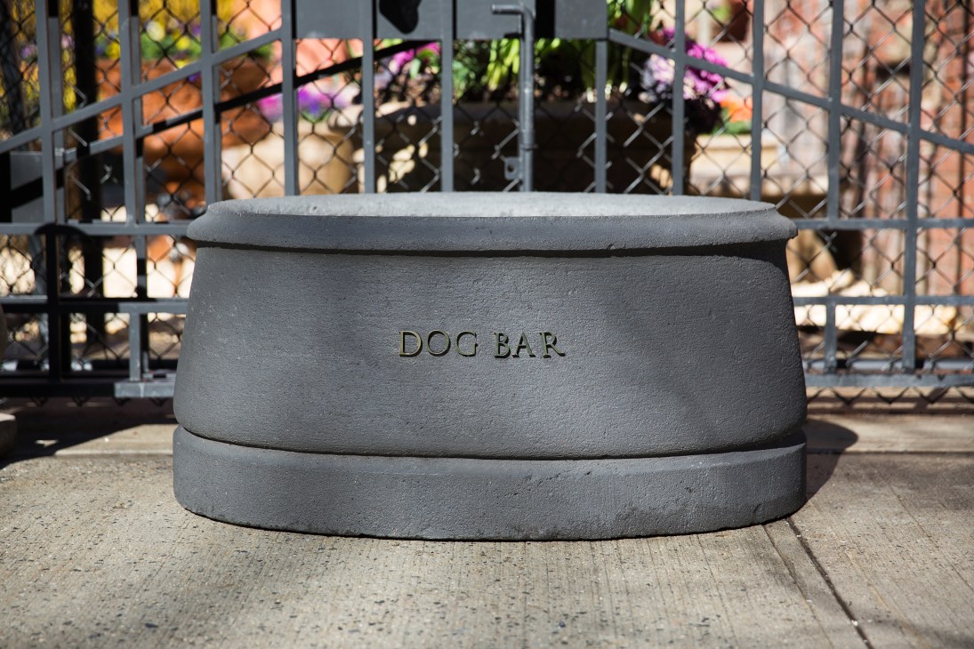 Grey concrete dog bowl engraved with 'DOG BAR' at Soho Grand hotel entrance in New York.
