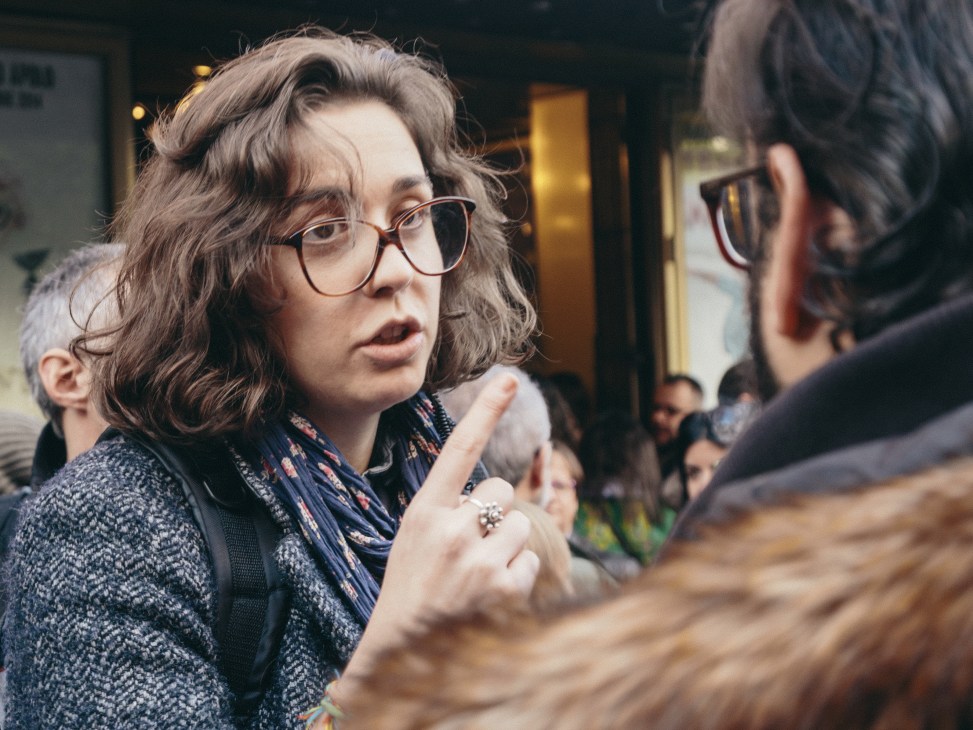 Maria José Benavente, media adviser for the Podemos party, wearing glasses and gesturing while speaking to someone off-camera.