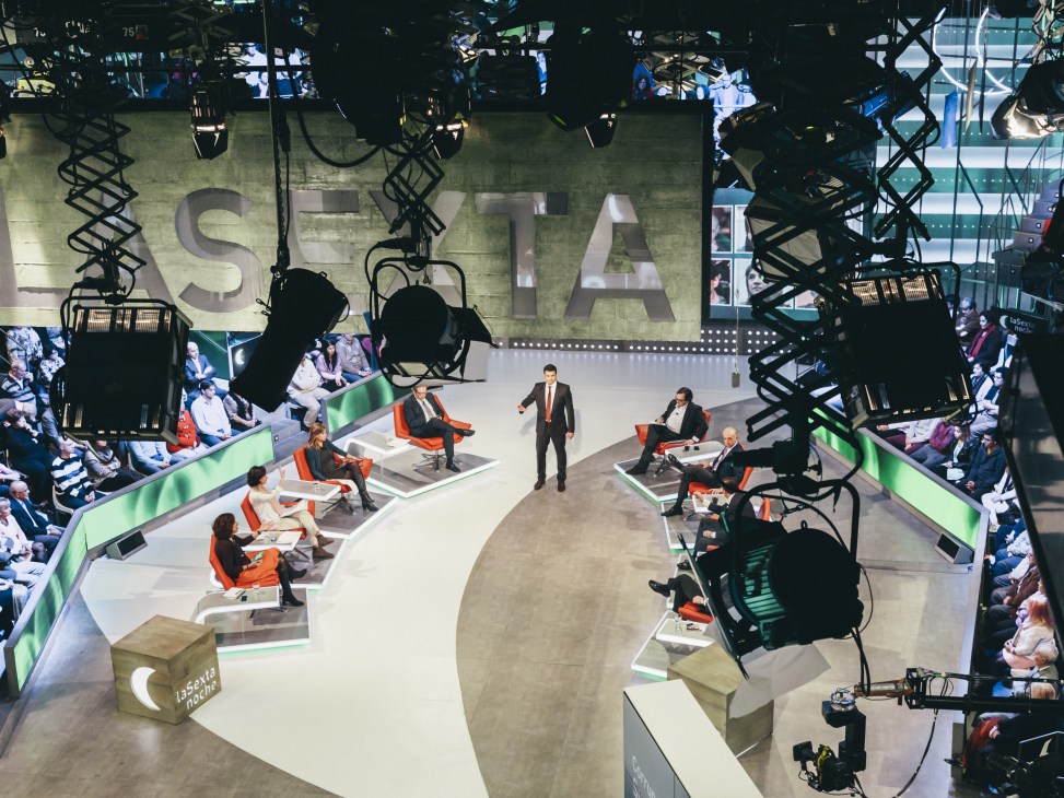 Overhead view of La Sexta Noche TV studio set with politicians seated in discussion areas surrounded by studio lighting rigs and audience seating.