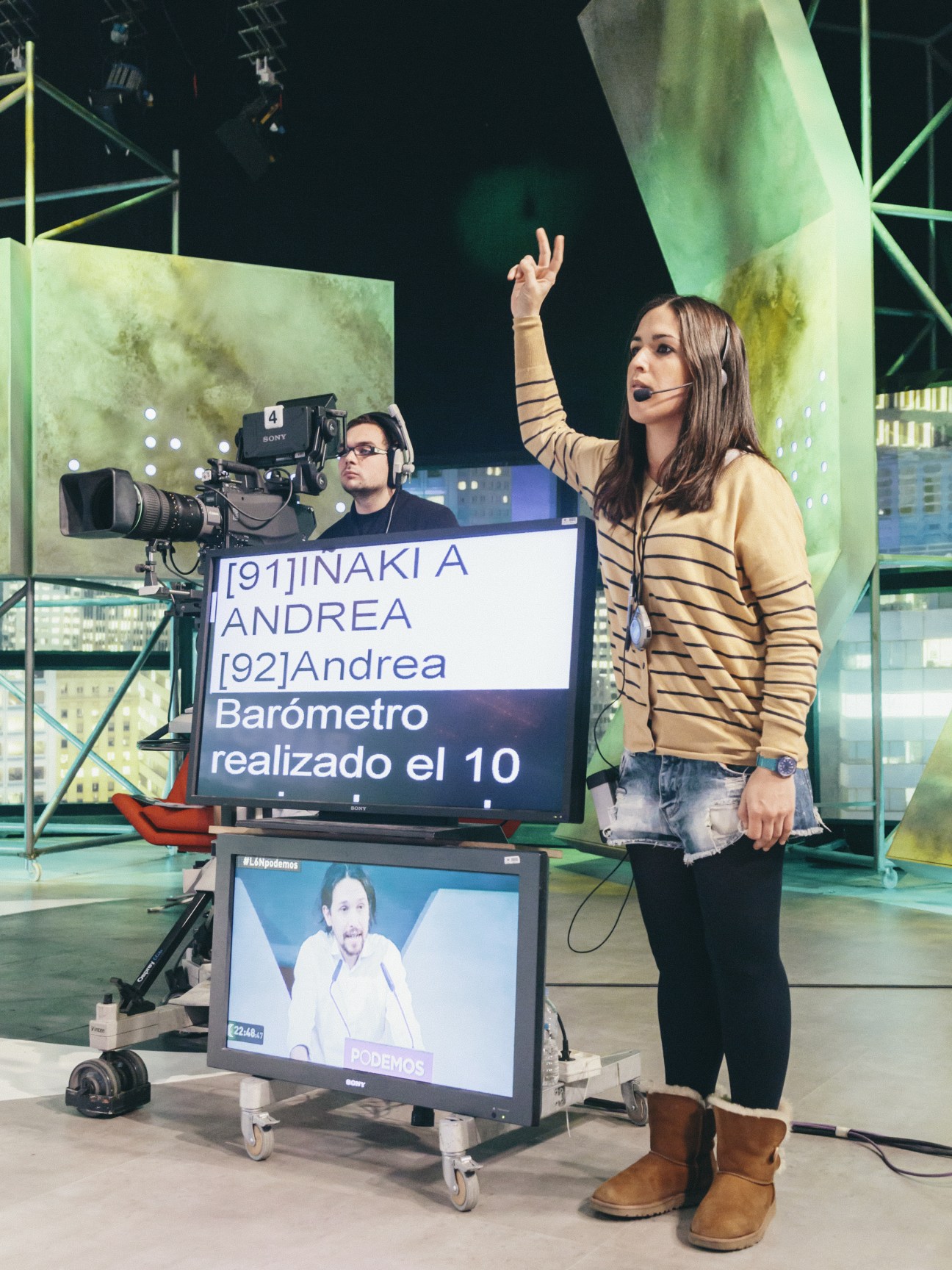 Floor manager Valentina Garcia gestures while wearing a headset during a live television broadcast.