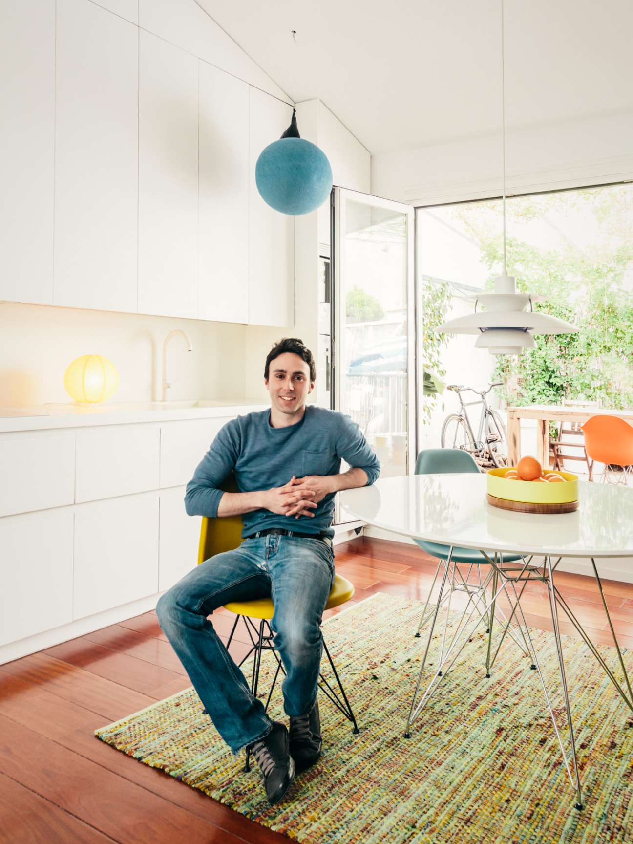 Architect Gonzalo Pardo sits at a white dining table in a modern kitchen with minimalist design and large windows.
