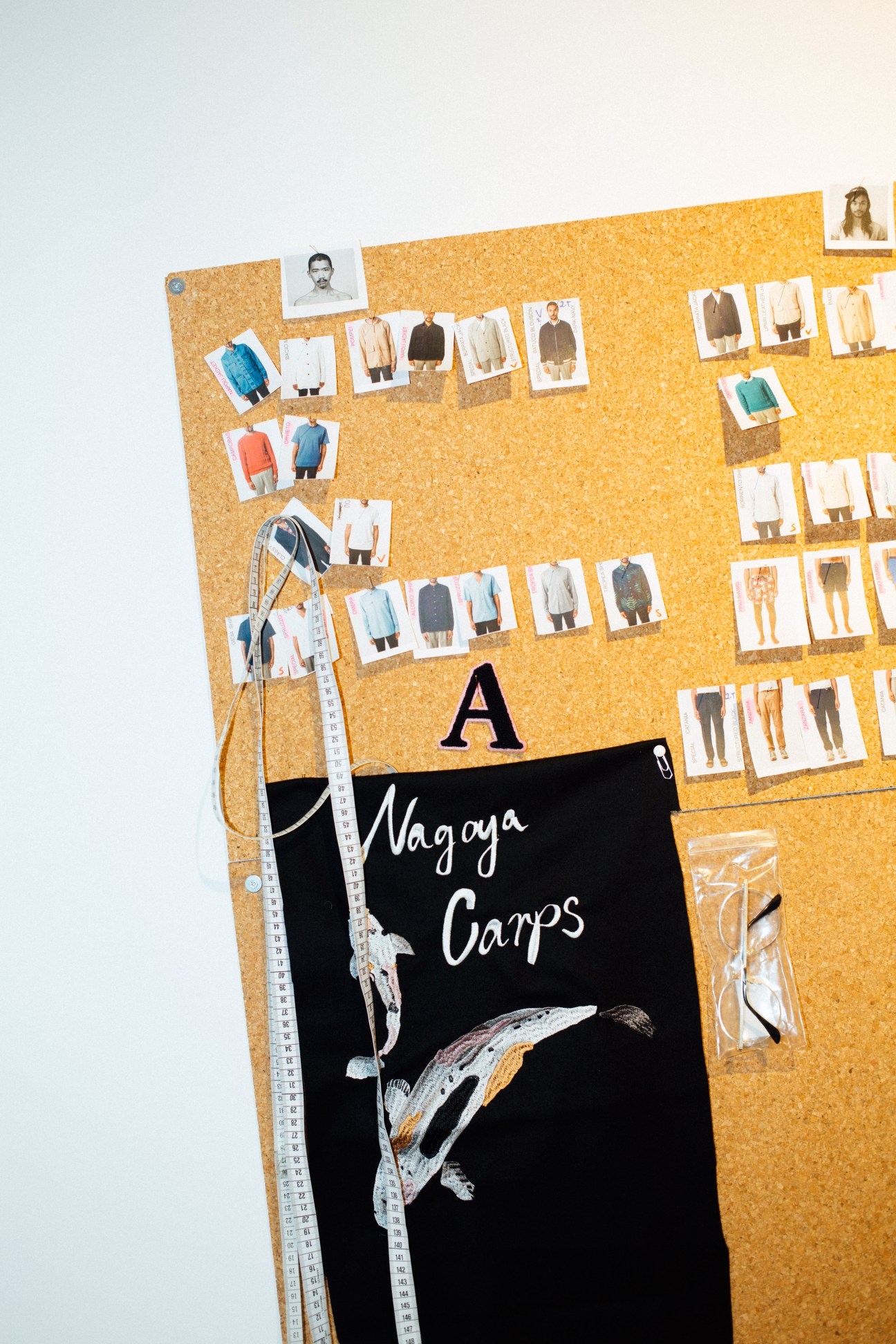 Cork moodboard displaying fashion design sketches and fabric swatches for A Kind of Guise's spring/summer 2017 collection.