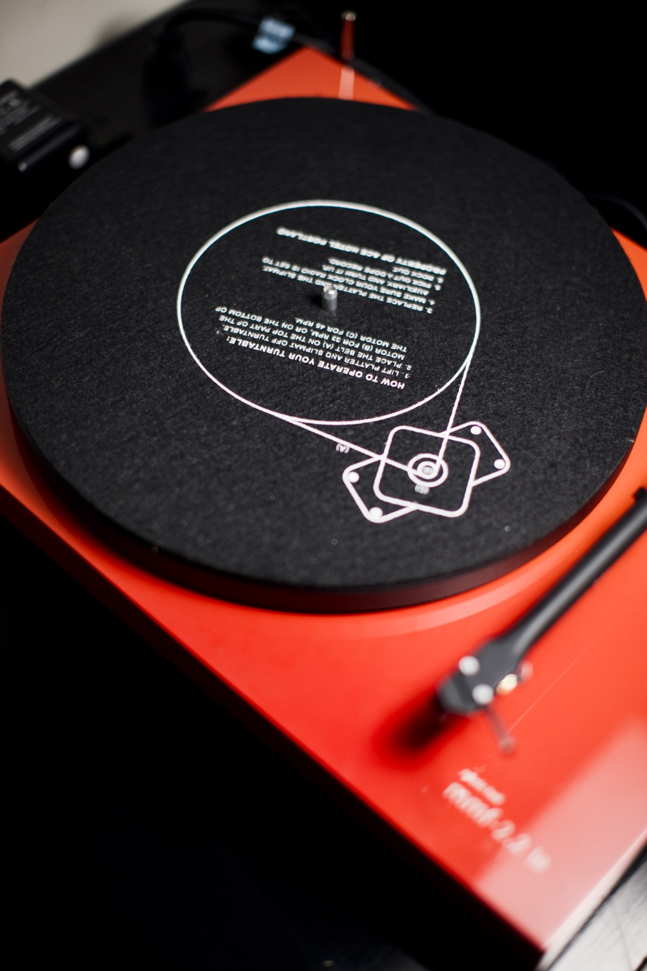 Red and black record player with custom Ace Hotel design on the turntable.