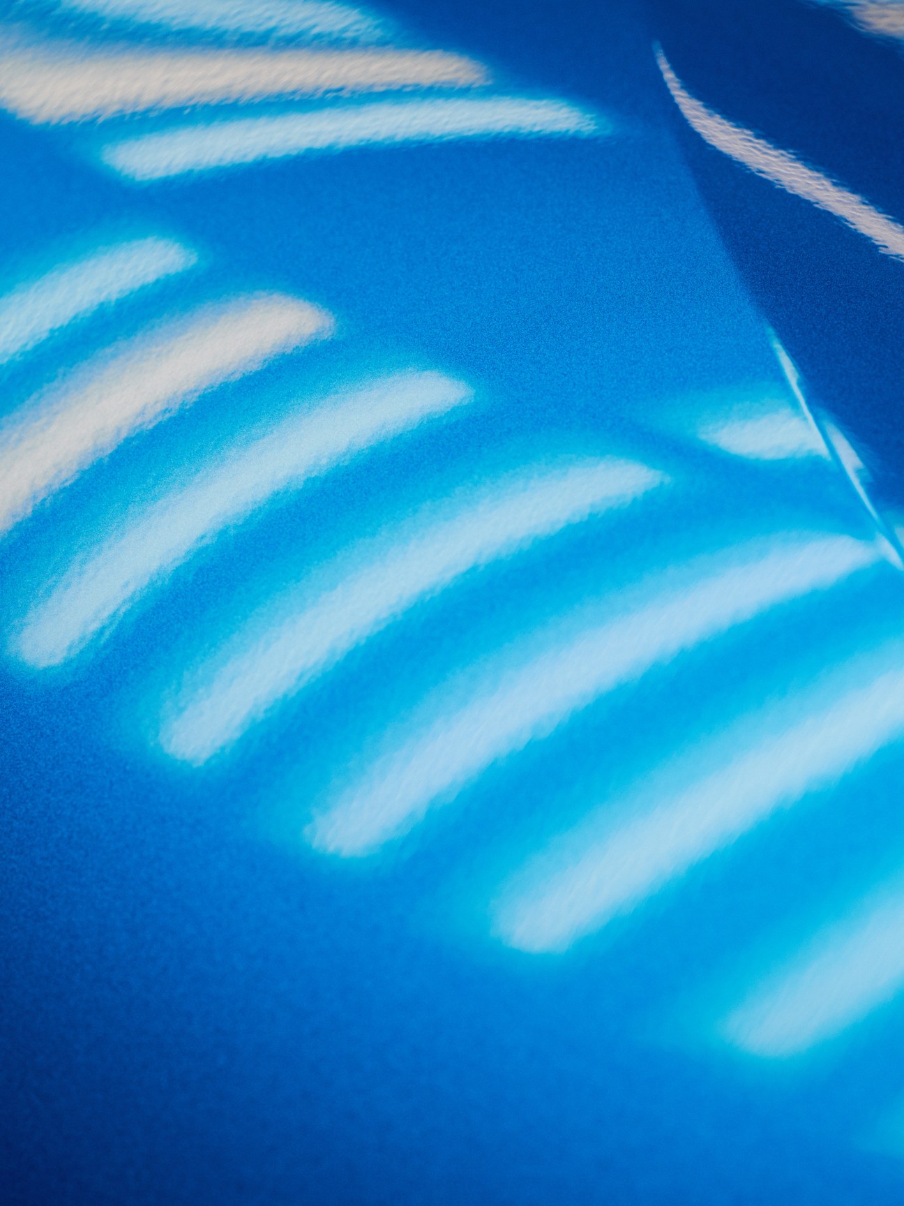 BMW i electric vehicle painted in Protonic Blue inside a manufacturing facility.