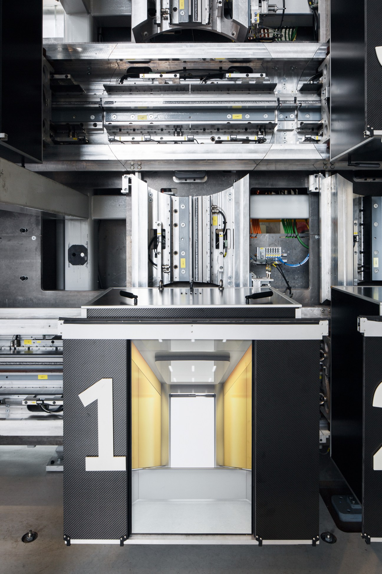 Overhead view of ThyssenKrupp Elevator's innovation centre testing equipment with mechanical components and yellow safety features.