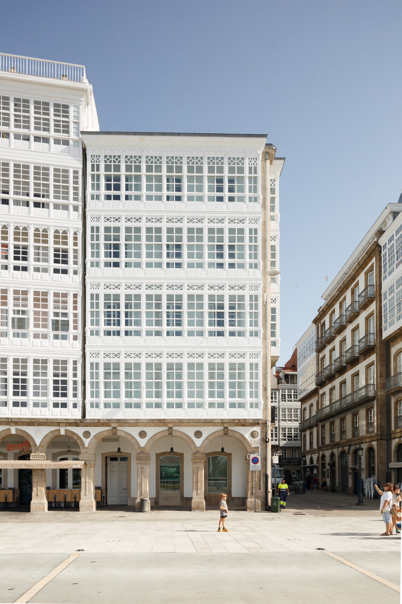 Historic white building with ornate facades and arched ground-floor windows in A Coruña's city center.