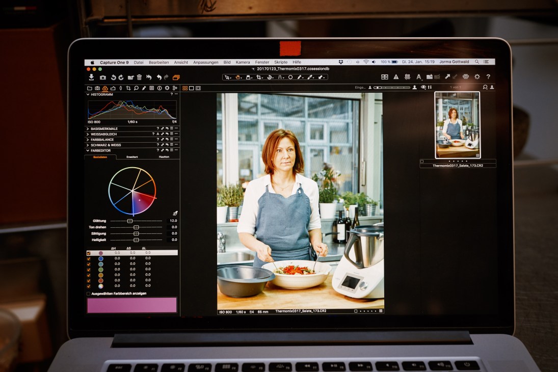Computer screen displaying photo editing software with image of woman preparing food with Thermomix processor.
