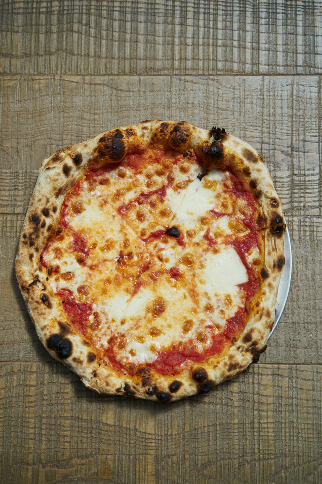 A Neapolitan-style pizza with tomato sauce, mozzarella, and charred crust from Yard Sale Pizza.