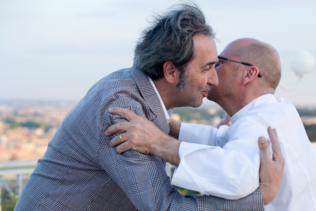 Chef Heinz Beck greets Paolo Sorrentino with an embrace on a terrace overlooking Rome.
