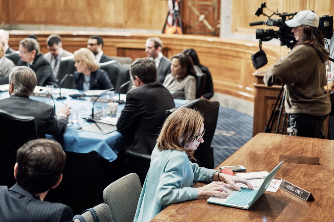 Political correspondent Lisa Desjardins at a press table during a Senate committee vote on Trump nominee Mick Mulvaney.