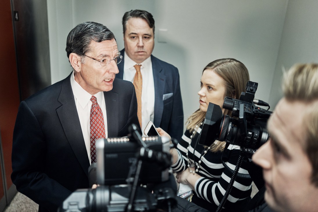 PBS Newshour politics producer Julie Percha interviews senator John Barrasso with camera and microphone.