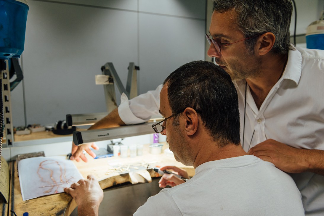 Two Armenian jewellery workers examine a design sketch at a workbench in Mouzannar's workshop.