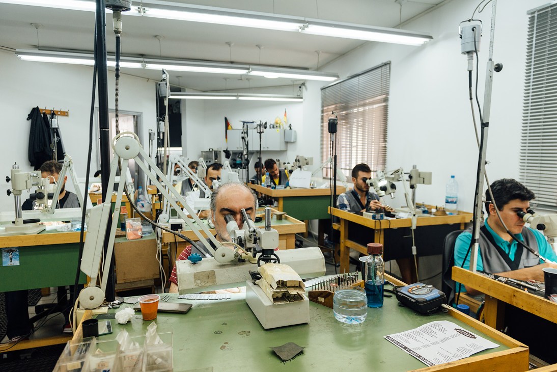 Armenian jewellers working at individual workstations with magnifying lamps in Yeprem's workshop.