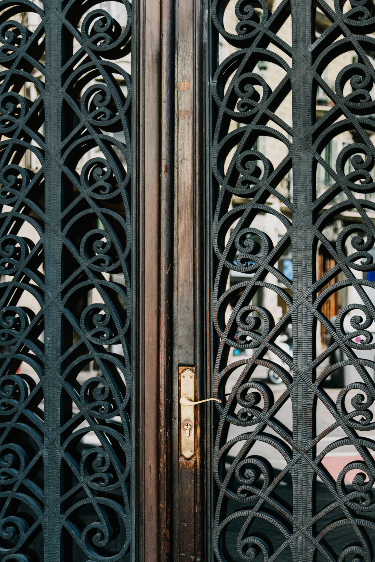 Ornate dark blue-green metal doors with intricate scrollwork and spiral patterns at Casa Xina entrance.