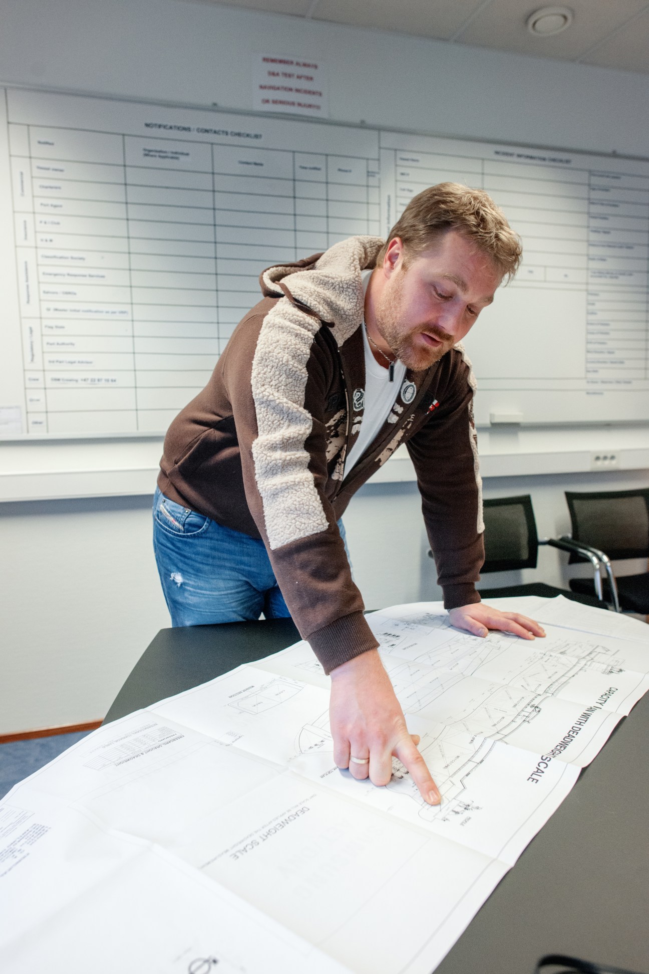 Chief officer Aslak Skripeland reviews blueprints of the Eagle Barents tanker at a table.