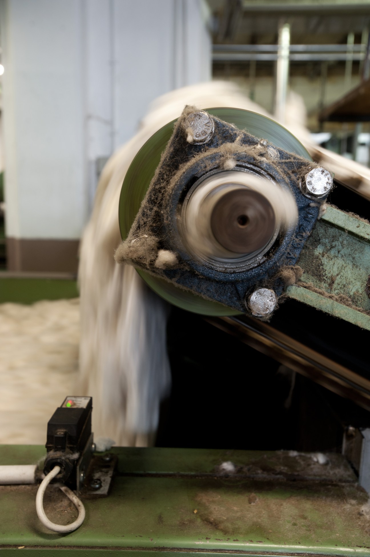 Industrial wool washing machinery with raw fleece and water spray at Reda mill