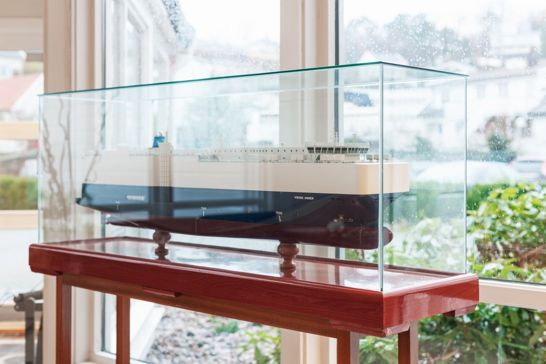 Model of the Viking Amber tanker ship displayed in a glass case with harbour view in background.